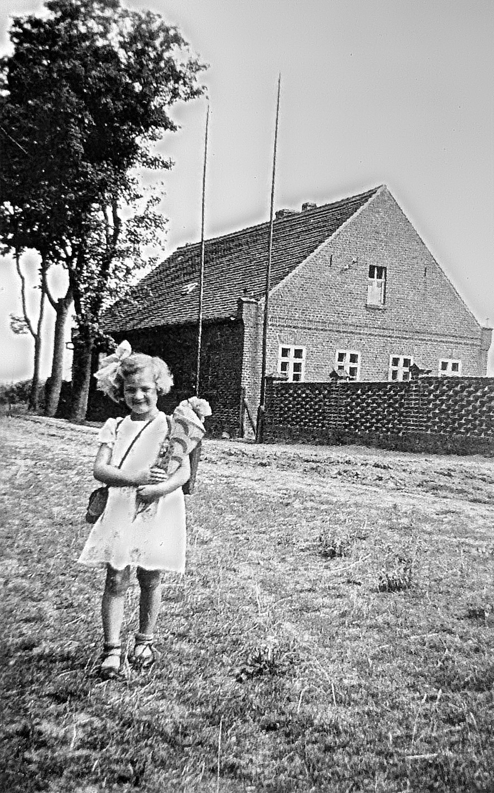 Mädchen mit Zuckertüte vor dem Schulhaus von Wuhden
