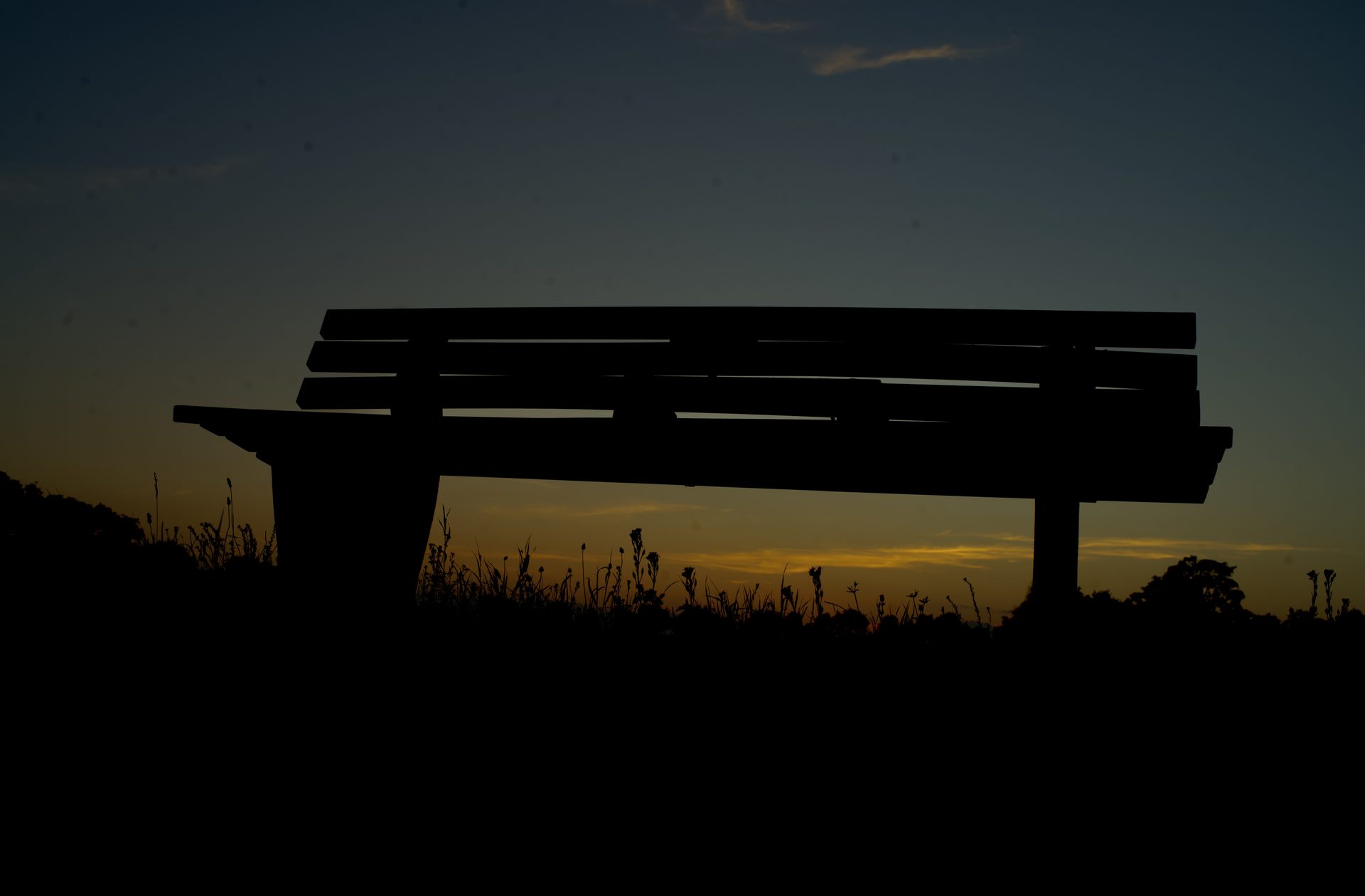 Die Bank als Silhouette gegen die untergehende Sonne